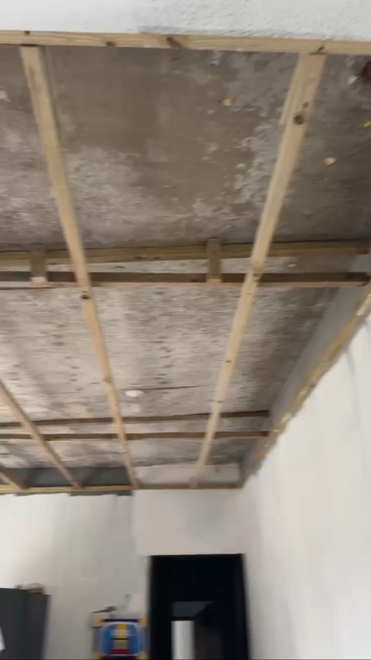 Timber batten framework prepared across a concrete ceiling before panel installation