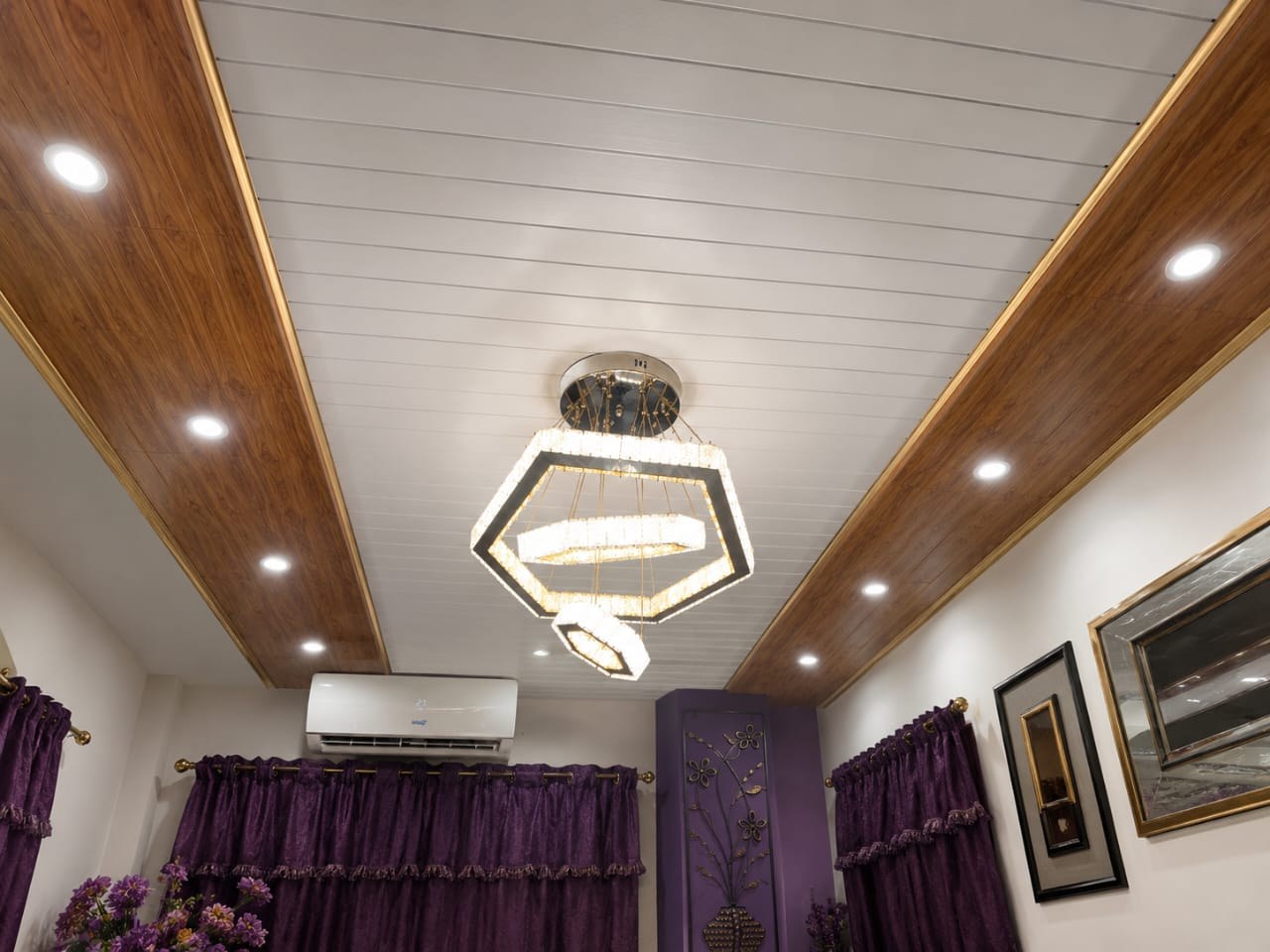 White plank ceiling with wood-grain border, gold trim and a crystal chandelier installed in a Kingston home